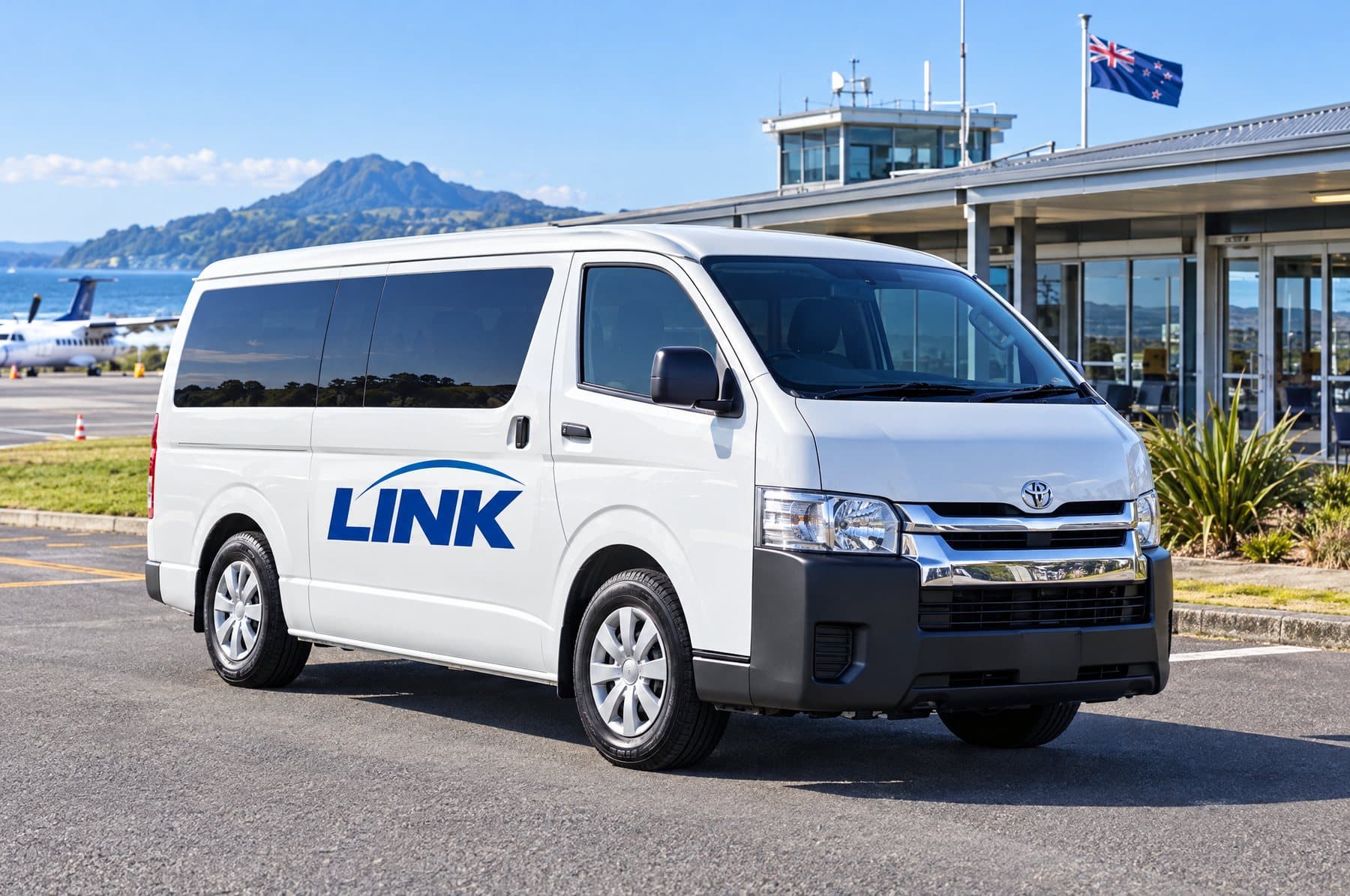 White LINK Hiace van outside an airport terminal